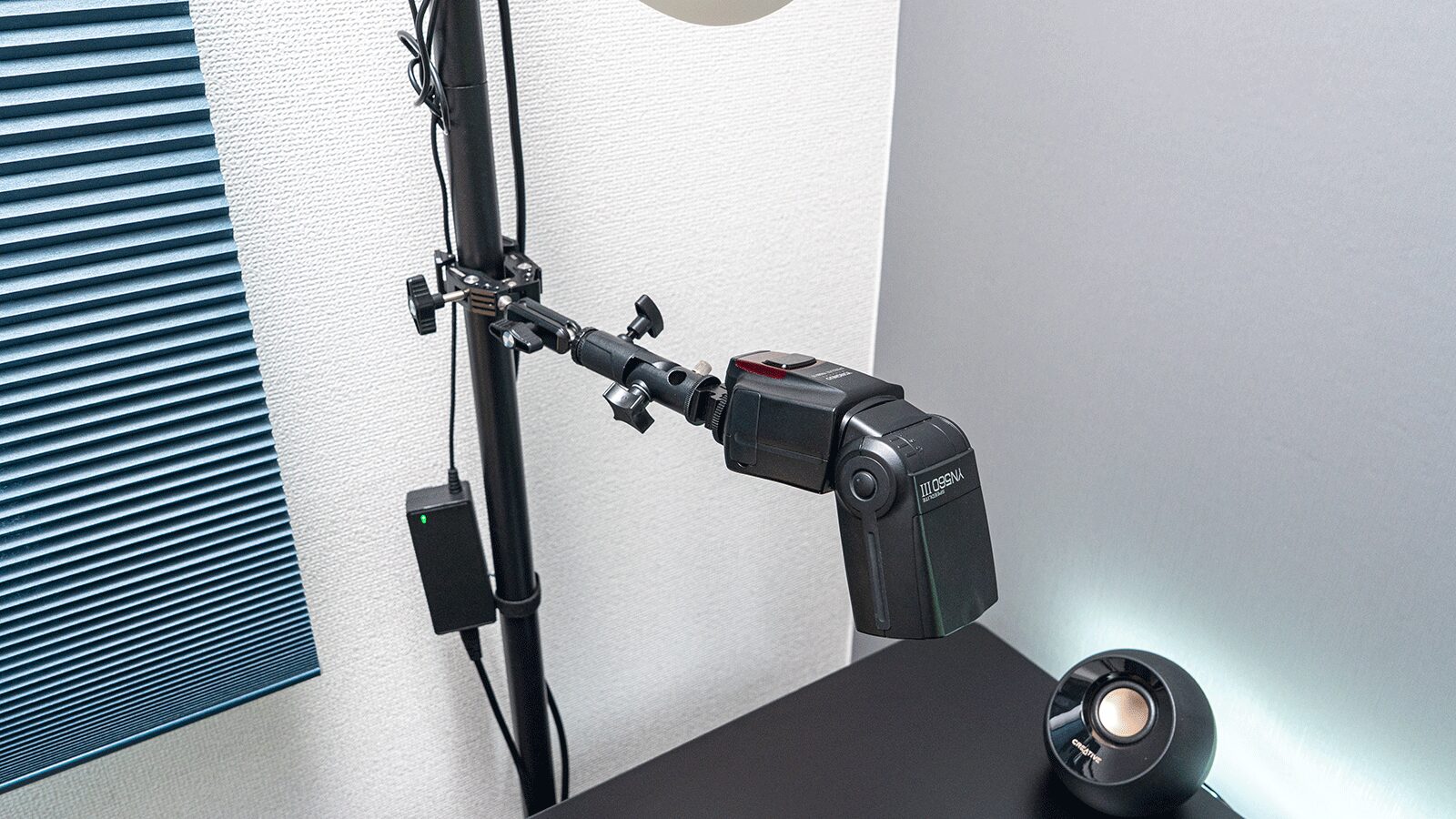 突っ張り棒をカメラ三脚やライティングシステム-Neewer スーパークランプ ストロボを取り付けた画像